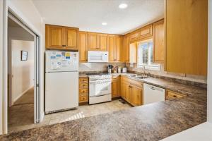 a kitchen with white appliances and wooden cabinets at 2816 - Tranquil Sound by Resort Realty in Duck