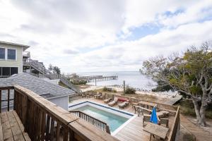 a balcony with a swimming pool and a beach at 2816 - Tranquil Sound by Resort Realty in Duck