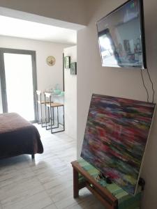 um quarto com uma pintura numa mesa com uma televisão na parede em Cipreses 1 MONOAMB EN EL CENTRO em San Martín de los Andes