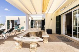 een patio met 2 tafels en stoelen op een balkon bij Villa Jordi - Cala en Porter in Cala'n Porter