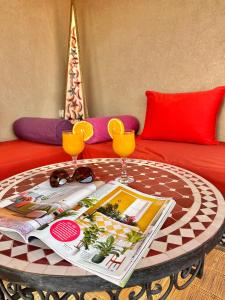 - une table basse avec deux verres sur un canapé dans l'établissement Riad Shaden, à Marrakech
