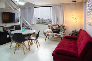 - un salon avec un canapé rouge et une table dans l'établissement Pequeno Paraíso Loft - Praia da Cal, à Torres