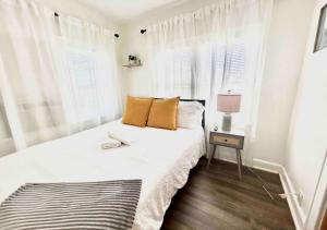 una camera bianca con un letto con tende bianche di Cozy 2 Bedroom Apartment Near Local Hotspots a West Palm Beach