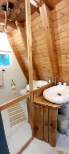 - une salle de bains avec deux lavabos dans une maison en bois dans l'établissement Cabanuta Sofia, à Slon