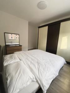 um quarto com uma cama branca e um micro-ondas em Private Apartment Prishtina em Pristina