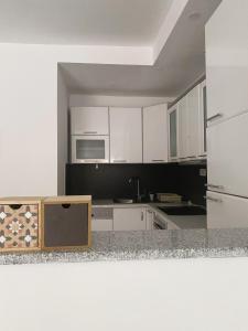 uma cozinha com armários brancos e uma bancada em Private Apartment Prishtina em Pristina