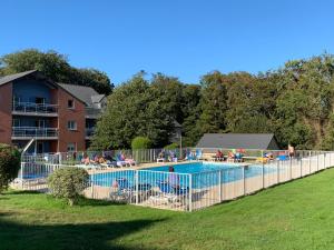 ein großer Swimmingpool mit Menschen in einem Park in der Unterkunft Appartement T3 équipé in Carantec