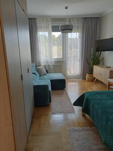uma sala de estar com duas camas e um sofá em Apartament Prowansalski em Gdansk