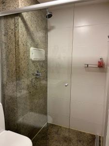 a shower with a glass door next to a toilet at CULLINAN DELUXE in Brasília