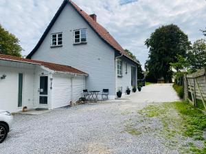 a white house with a driveway in front of it at Cosy private room in Slagelse