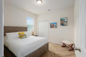 a white bedroom with a bed and a chair at Villa Ilse: New Stylish Home With Private Pool in Inverness +10 photos