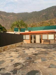 a house with a large patio with mountains in the background at CASITA LAS VISTAS in Frontera
