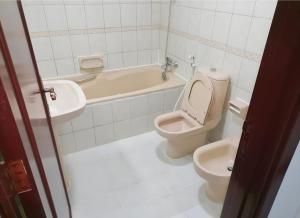 a bathroom with a toilet and a tub and a sink at Corniche AD - Superb Lovely Room in Abu Dhabi