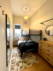 sypialnia z łóżkiem, komodą i lustrem w obiekcie Lossie Self-Catering Apartment w mieście Lossiemouth
