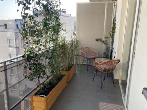 a balcony with chairs and plants on a building at Przestronny apartament na Dolnej in Warsaw