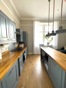 uma cozinha com armários azuis e um balcão de madeira em Lossie Self-Catering Apartment em Lossiemouth