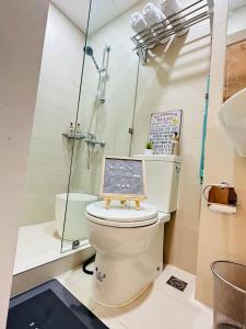 La salle de bains est pourvue de toilettes et d'un panneau. dans l'établissement Cozy Studio Penthouse I Wi-Fi I Netflix l Pool, à Manille
