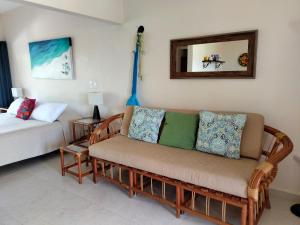 a living room with a couch and a mirror at Cabañas Puerto Morelos in Puerto Morelos