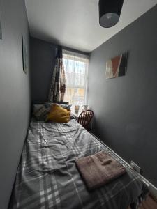 um quarto com uma cama no canto de um quarto em Hatton Homes: Tottenham (Thackery Avenue) em Londres