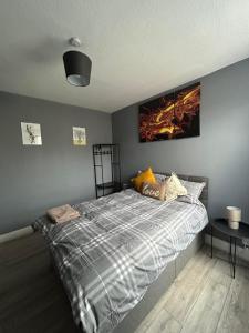 um quarto com uma cama com um quadro na parede em Hatton Homes: Tottenham (Thackery Avenue) em Londres