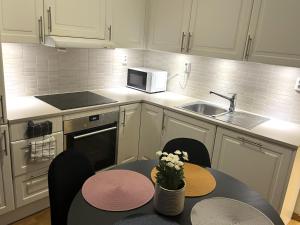a kitchen with a table with chairs and a microwave at Scandpoint Apartment Lillestrom -Cosy 3 rooms flat with free Parking, EV Charger 18 min from Airport in Lillestrøm