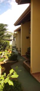 a hallway of a building with green plants and a building at Suítes Jardim dos Sonhos in Ubatuba +9 photos