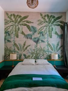 um quarto com uma cama com uma parede com palmeiras em Lyon Faubourg - Saint Priest em Saint-Priest