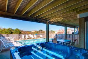 una gran piscina con una terraza con mesa y sillas en 4611 - Prescription OBX, en Southern Shores