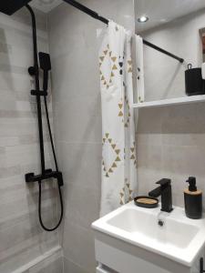 a bathroom with a sink and a shower curtain at Potkrovlje u centru in Sarajevo