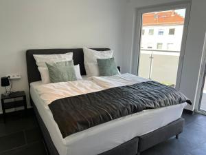 een groot bed in een slaapkamer met een groot raam bij Modern Apartment Mainz by PMA in Mainz