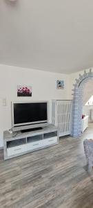 a living room with a television on a entertainment center at Ferienwohnung, Urlaub im Frankenwald in Konradsreuth