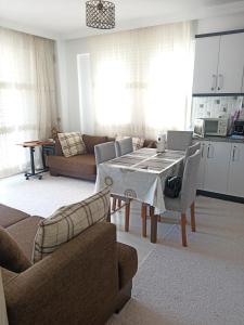 a kitchen and a living room with a table and chairs at 2 Yatak Odalı Daire-Fethiye in Fethiye