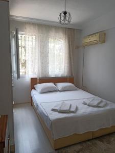 een slaapkamer met een bed met twee handdoeken erop bij 2 Yatak Odalı Daire-Fethiye in Fethiye