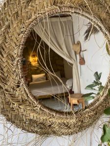 a wicker mirror hanging on a wall in a room at AJARIF ⴰⵊⴰⵔⵉⴼ - Fisherman cabin in Tamri