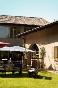 a patio with tables and chairs and umbrellas at Locanda Cà dei Santi in Induno Olona