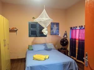 um quarto com uma cama com toalhas amarelas em MERMAID HOUSE, casa charmoso, wifi, parking, jardim, cozinha, central CANOA QUEBRADA em Aracati