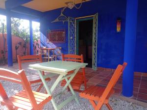 a table and chairs in a room with a blue wall at Mermaid House, kitchen, Wi-Fi, parking, centre 5 minutes on foot and near Sunset Dune in Aracati