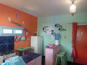 una cucina con pareti arancioni e frigorifero bianco di MERMAID HOUSE, casa charmoso, wifi, parking, jardim, cozinha, central CANOA QUEBRADA a Aracati