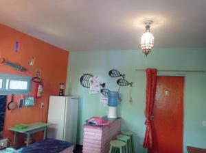 - une cuisine avec des murs orange et un réfrigérateur dans l'établissement MERMAID HOUSE, casa charmoso, wifi, parking, jardim, cozinha, central CANOA QUEBRADA, à Aracati