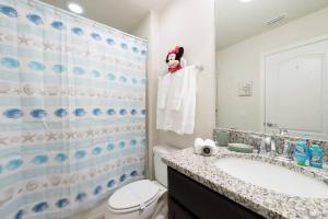 a bathroom with a sink and a toilet and a shower at The Happy Place! - Upgraded Fun Windsor Home in Kissimmee
