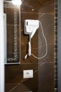 a phone on a wall with a cord plugged into it at Hotel Univers in Kolgecaj