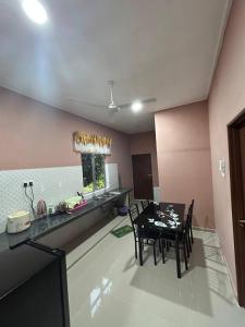 a kitchen and dining room with a table and chairs at Homestay Taman Hidayah Chawas in Tanah Merah