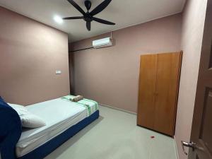 een slaapkamer met een bed en een plafondventilator bij Homestay Taman Hidayah Chawas in Tanah Merah