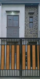ein schwarzer Zaun mit Holztüren vor einem Haus in der Unterkunft 1BR Townhouse + Netflix in Marilao
