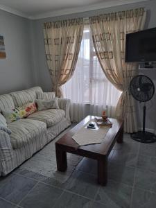 a living room with a couch and a coffee table at Coastal Cottage in Klein-Brakrivier