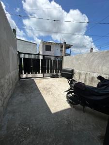 ein Motorrad, das vor einem Zaun parkt in der Unterkunft 1BR Townhouse + Netflix in Marilao