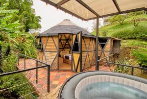 HOTEL KOKUMI في ريونيغرو: شرفة مع حوض استحمام ساخن بجوار منزل