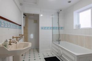 a white bathroom with a tub and a sink at Quality Stay Room in Brighton & Hove