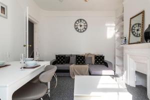 a living room with a couch and a clock on the wall at Quality Stay Room in Brighton & Hove +10 photos