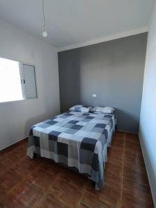 - une chambre avec un lit et une couverture en damier dans l'établissement Casa da Palmeira, à Tatuí
